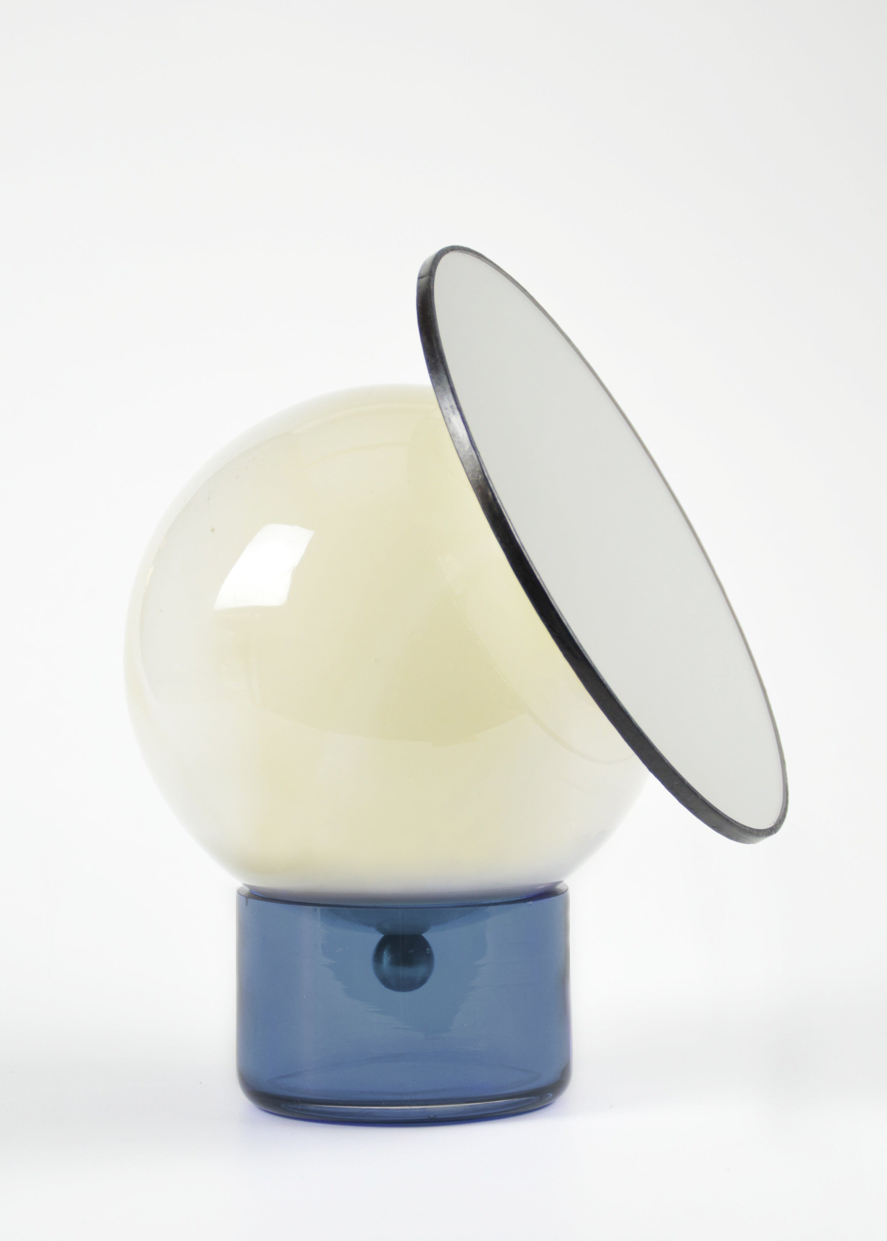Miroir orientable cerclé de cuir, composé d’une sphère en verre soufflé au décor blanc marbré et d’une base en verre bleu.