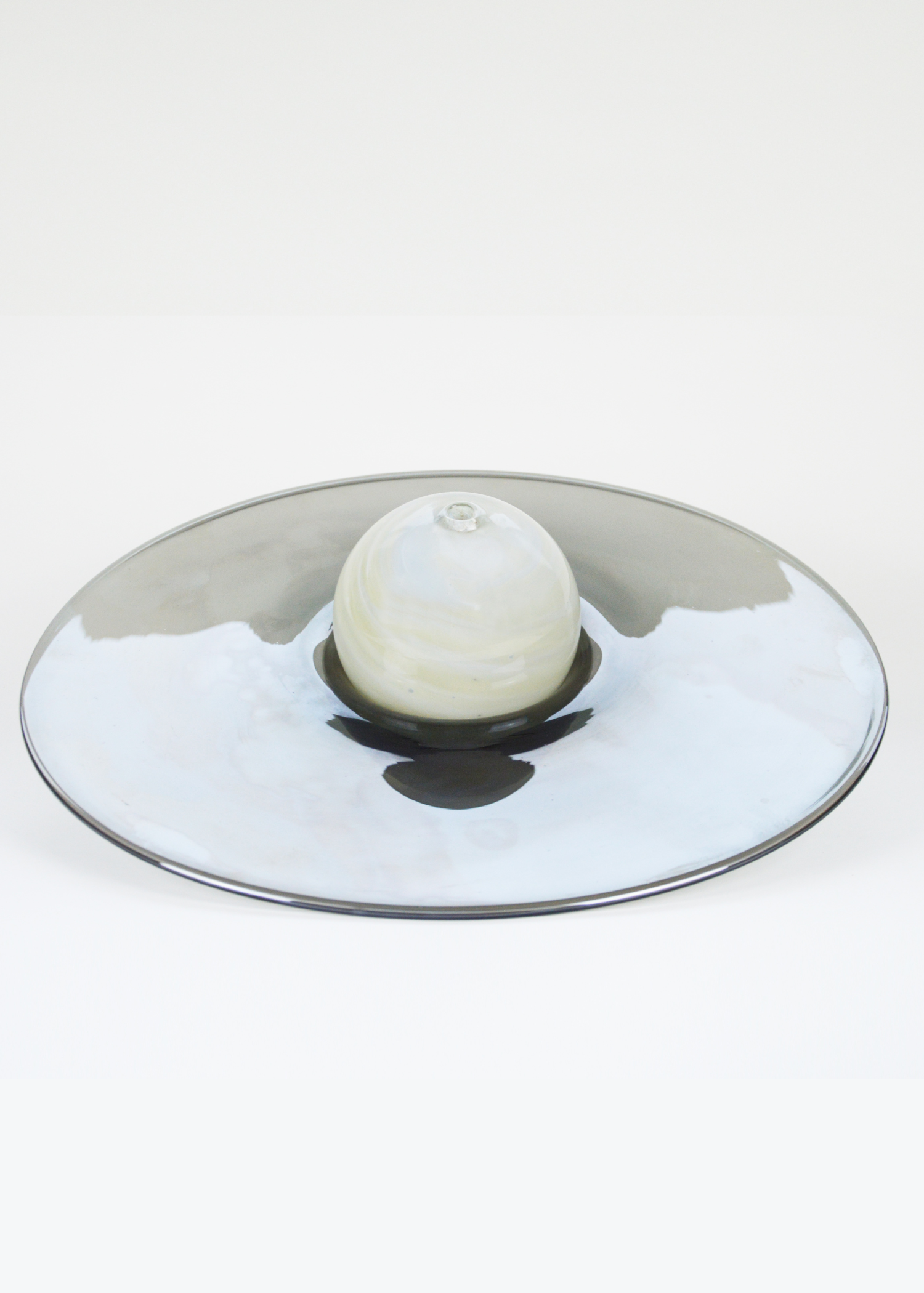 Soliflore, fabriqué à la main en France, composé d’une sphère ivoire aux décors de marbrures posée dans un réceptacle en verre noir.
